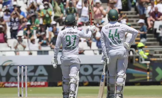 South Africa's Kyle Verreynne, left, celebrates his 50 while teammate South Africa's Ryan Rickelton looks on during the second day of the second test match between South Africa and Pakistan in Cape Town, South Africa, Saturday, Jan. 4, 2025. (AP Photo/Halden Krog)