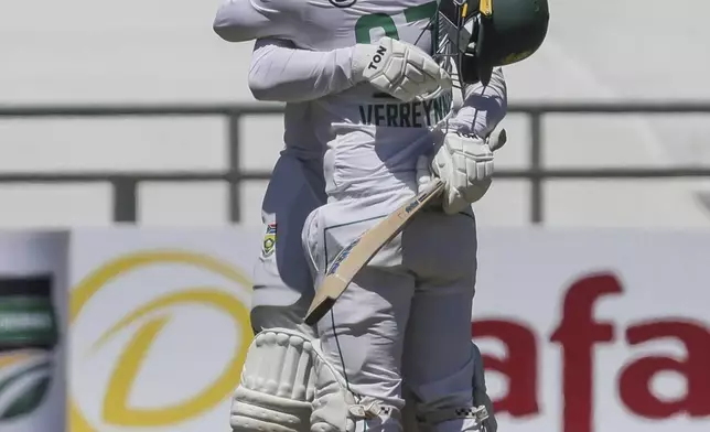 South Africa's Ryan Rickelton is congratulated by teammate Kyle Verreynne after scoring 200 runs during the second day of the second test match between South Africa and Pakistan in Cape Town, South Africa, Saturday, Jan. 4, 2025. (AP Photo/Halden Krog)