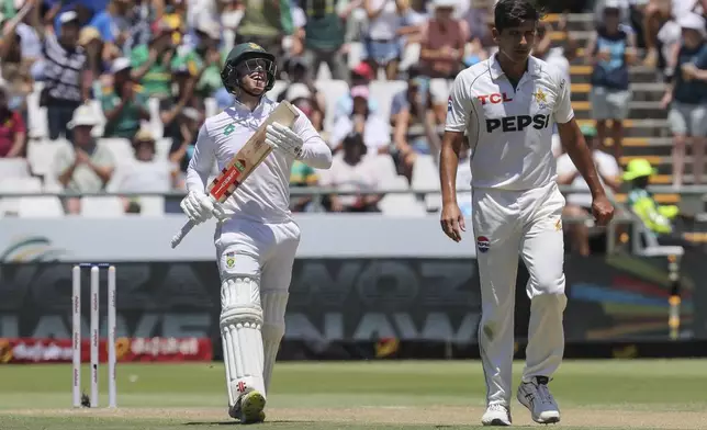 South Africa's Kyle Verreynne celebrates his 50 from the bowling of Pakistan's Aamer Jamal, right, during the second day of the second test match between South Africa and Pakistan in Cape Town, South Africa, Saturday, Jan. 4, 2025. (AP Photo/Halden Krog)