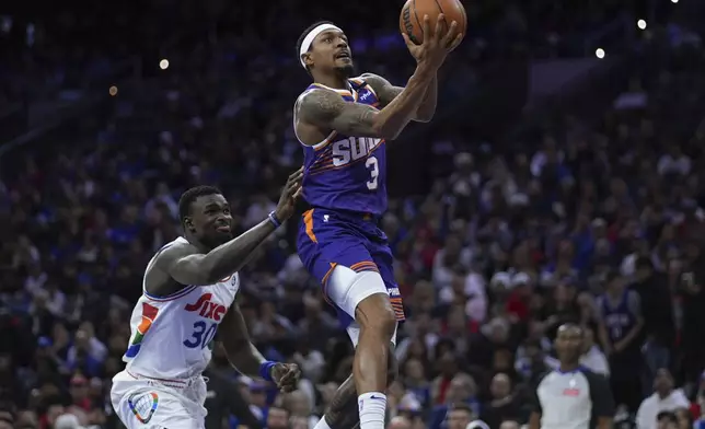 Phoenix Suns' Bradley Beal, right, goes up for a shot against Philadelphia 76ers' Adem Bona during the second half of an NBA basketball game, Monday, Jan. 6, 2025, in Philadelphia. (AP Photo/Matt Slocum)