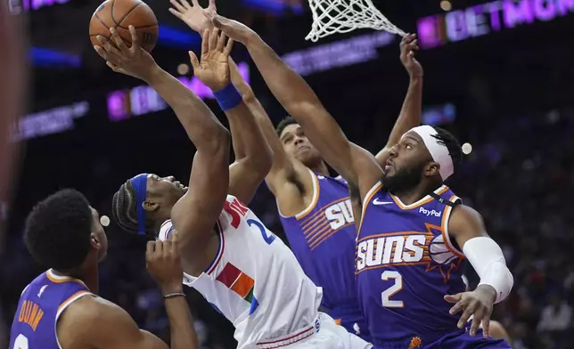 Philadelphia 76ers' Guerschon Yabusele, center, goes up for a shot against Phoenix Suns' Ryan Dunn, from left, Oso Ighodaro and Josh Okogie during the first half of an NBA basketball game, Monday, Jan. 6, 2025, in Philadelphia. (AP Photo/Matt Slocum)