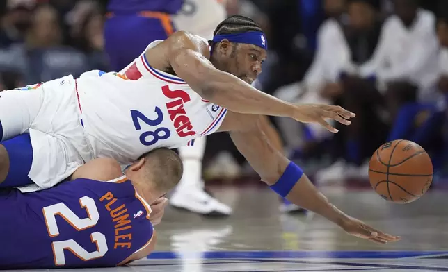 Philadelphia 76ers' Guerschon Yabusele, top, dives for a loose ball over Phoenix Suns' Mason Plumlee during the second half of an NBA basketball game, Monday, Jan. 6, 2025, in Philadelphia. (AP Photo/Matt Slocum)