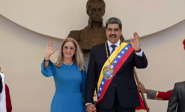 Venezuelan President Nicolas Maduro and his wife Cilia Flores wave after his swearing-in ceremony for a third term in Caracas, Venezuela, Friday, Jan. 10, 2025. (AP Photo/Ariana Cubillos)