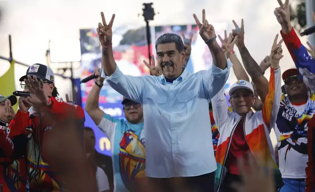 FILE - Venezuelan President Nicolas Maduro flashes victory hand signs at supporters during a pro-government rally, in Caracas, Venezuela, Aug. 17, 2024. (AP Photo/Cristian Hernandez, File)