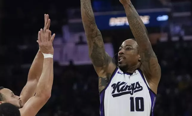 Sacramento Kings forward DeMar DeRozan, right, shoots over Golden State Warriors guard Stephen Curry, left, during the first half of an NBA basketball game, Sunday, Jan. 5, 2025, in San Francisco. (AP Photo/Godofredo A. Vásquez)