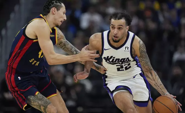 Sacramento Kings guard Devin Carter, right, moves the ball while defended by Golden State Warriors forward Lindy Waters III, left, during the first half of an NBA basketball game Sunday, Jan. 5, 2025, in San Francisco. (AP Photo/Godofredo A. Vásquez)