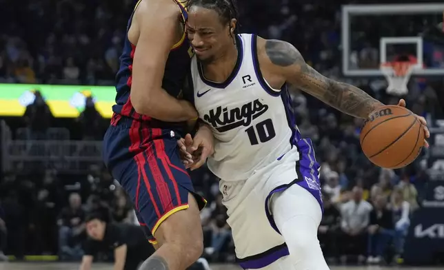 Sacramento Kings forward DeMar DeRozan, right, moves the ball while defended by Golden State Warriors forward Kyle Anderson during the first half of an NBA basketball game, Sunday, Jan. 5, 2025, in San Francisco. (AP Photo/Godofredo A. Vásquez)