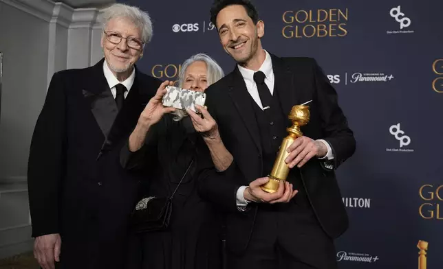 Elliot Brody, from left, Sylvia Plachy, and Adrien Brody, winner of the award for best performance by a male actor in a motion picture drama for "The Brutalist", pose in the press room during the 82nd Golden Globes on Sunday, Jan. 5, 2025, at the Beverly Hilton in Beverly Hills, Calif. (AP Photo/Chris Pizzello)