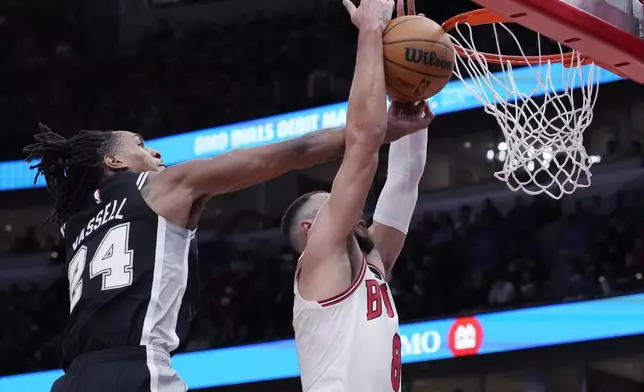 San Antonio Spurs guard Devin Vassell, left, blocks a dunk-attempt by Chicago Bulls guard Zach LaVine, right, during the first half of an NBA basketball game in Chicago, Monday, Jan. 6, 2025. (AP Photo/Nam Y. Huh)