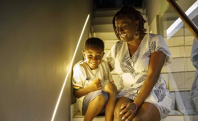 Maya Gilliam, 40, and her son, Neteru, 8, pose for a photograph in their home in Accra, Ghana, Wednesday, Dec. 11, 2024. Gilliam relocated from Winston-Salem, North Carolina, to Ghana and is awaiting Ghanaian citizenship. (AP Photo/Misper Apawu)