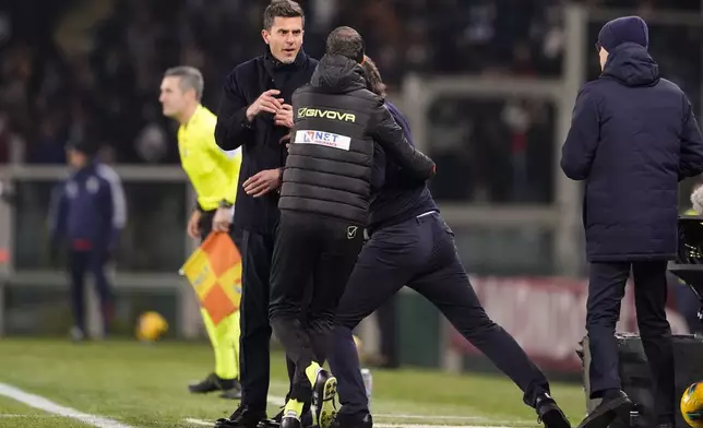 Torino's head coach Paolo Vanoli is held back as he attempts to push Juventus' head coach Thiago Motta, in a confrontation during their Italian Serie A soccer match at the Stadio Olimpico Grande Torino, in Turin, Italy, Saturday, Jan. 11, 2025. (Fabio Ferrari/Lapresse via AP)