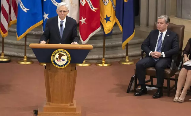 Attorney General Merrick Garland speaks as FBI Director Christopher Wray listens during a farewell ceremony at the Department of Justice, Thursday, Jan. 16, 2025, in Washington. (AP Photo/Mark Schiefelbein)