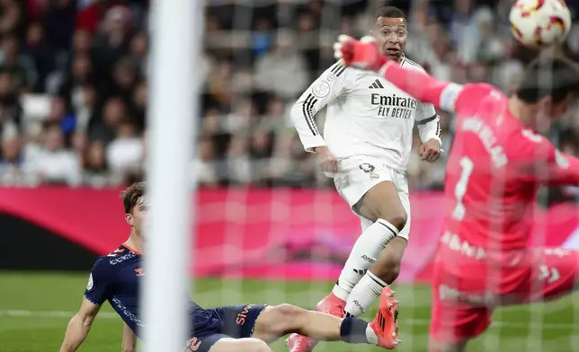 Real Madrid's Kylian Mbappe, back, scores his side's first goal against Celta de Vigo during a Copa del Rey round of 16 soccer match at the Santiago Bernabeu stadium in Madrid, Spain, Thursday, Jan. 16, 2025. (AP Photo/Pablo Garcia)