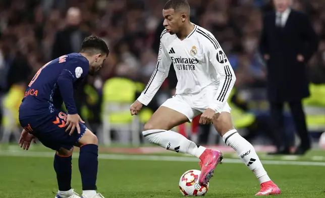 Real Madrid's Kylian Mbappe, right, dribbles past to Celta's Fran Beltran during a Copa del Rey round of 16 soccer match at the Santiago Bernabeu stadium in Madrid, Spain, Thursday, Jan. 16, 2025. (AP Photo/Pablo Garcia)