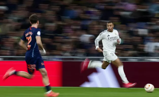 Real Madrid's Kylian Mbappe, right, controls a ball chased by Celta's Javi Rodriguez during a Copa del Rey round of 16 soccer match at the Santiago Bernabeu stadium in Madrid, Spain, Thursday, Jan. 16, 2025. (AP Photo/Pablo Garcia)