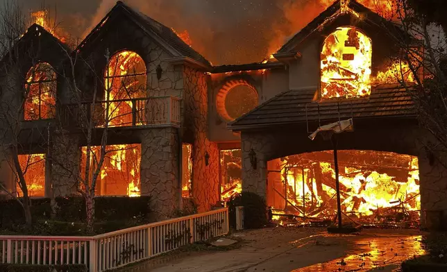 The Palisades Fire burns a structure in the Pacific Palisades neighborhood of Los Angeles, Wednesday, Jan. 8, 2025. (AP Photo/Eugene Garcia)