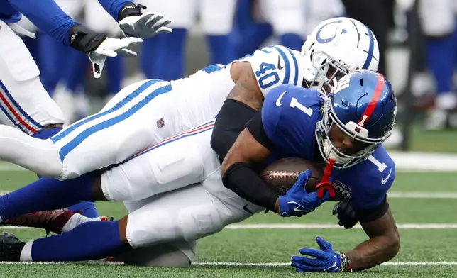 New York Giants wide receiver Malik Nabers (1) is brought down by Indianapolis Colts cornerback Jaylon Jones (40) in the first half of an NFL football game Sunday, Dec. 29, 2024, in East Rutherford, N.J. (AP Photo/Corey Sipkin)