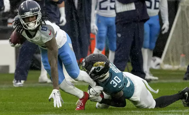 Tennessee Titans wide receiver Calvin Ridley (0) is tackled by Jacksonville Jaguars cornerback Montaric Brown (30) after a catch during the first half of an NFL football game, Sunday, Dec. 29, 2024, in Jacksonville, Fla. (AP Photo/John Raoux)