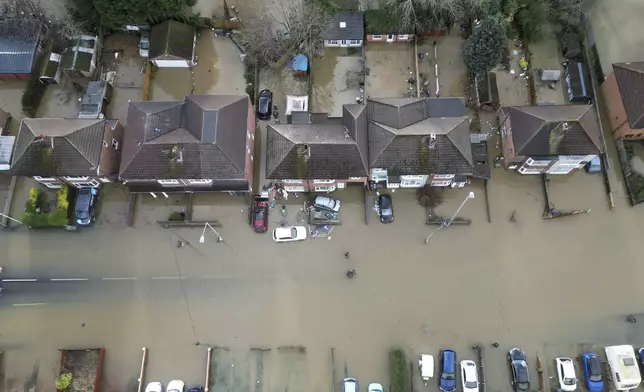 Homes stand in flood water after the Grand Union Canal burst its banks in Loughborough, England, Tuesday, Jan. 7, 2025. (AP Photo/Darren Staples)