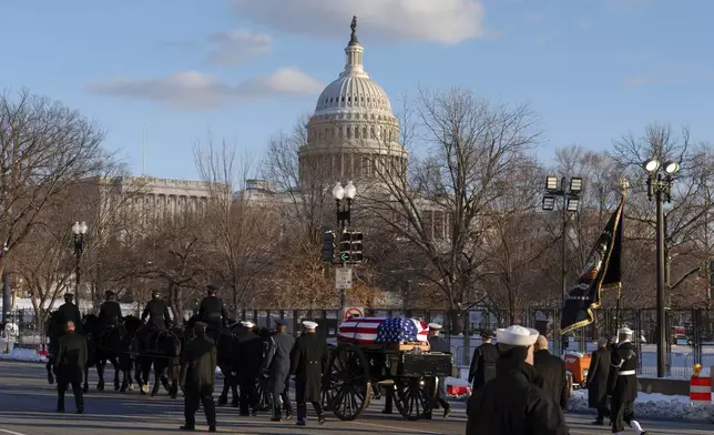 With the U.S. Capitol in the background the flag-draped casket of President Jimmy Carter moves toward the U.S. Capitol on a horse-drawn caisson at Constitution Avenue on Capitol Hill, Tuesday, Jan. 7, 2025, in Washington. Carter died Dec. 29, at the age of 100. (AP Photo/Jose Luis Magana)