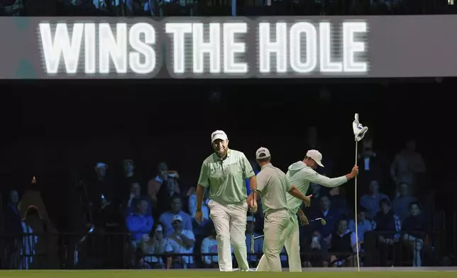 The Bay Golf Club's Shane Lowry, left, and teammates react as they beat New York Golf Club on the third hole, during the inaugural match of the TMRW Golf League, Tuesday, Jan. 7, 2025, in Palm Beach Gardens, Fla. TGL features six teams of four players competing against each other in a tech-infused arena the size of a football field. (AP Photo/Rebecca Blackwell)