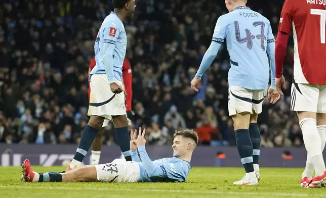 Manchester City's James McAtee, bottom, celebrates after scoring his side's eighth goal during the English FA Cup soccer match between Manchester City and Salford City at Etihad Stadium in Manchester, Saturday, Jan. 11, 2025. (AP Photo/ Dave Thompson)
