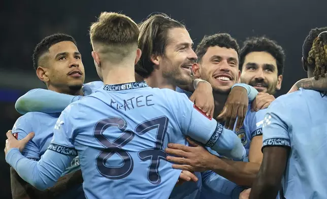 Manchester City's Jack Grealish, centre, celebrates after scoring his side's fourth goal during the English FA Cup soccer match between Manchester City and Salford City at Etihad Stadium in Manchester, Saturday, Jan. 11, 2025. (AP Photo/ Dave Thompson)