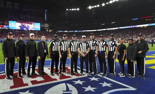 Officials including side judge Eugene Hall; side judge Allen Baynes; back judge Tony Josselyn; referee John Hussey; down judge Dana McKenzie; back judge Matt Edwards and umpire Terry Killens pose before an NFL wild card playoff football game between the Los Angeles Rams and Minnesota Vikings, Monday, Jan. 13, 2025, in Glendale, Ariz. (AP Photo/Ross D. Franklin)