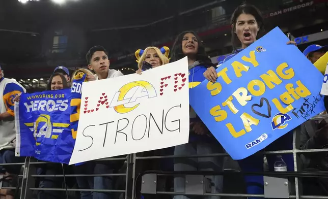 Los Angeles Rams fans hold a signs before an NFL wild card playoff football game against the Minnesota Vikings, Monday, Jan. 13, 2025, in Glendale, Ariz. (AP Photo/Ross D. Franklin)
