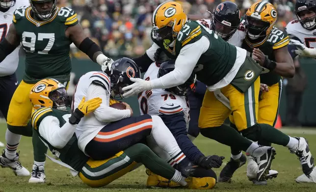 Green Bay Packers defensive end Rashan Gary, bottom left, tackles Chicago Bears quarterback Caleb Williams, middle left, during the first half of an NFL football game, Sunday, Jan. 5, 2025, in Green Bay, Wis. (AP Photo/Morry Gash)