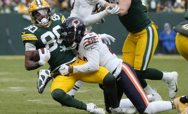 Green Bay Packers wide receiver Bo Melton (80) is tackled by Chicago Bears cornerback Tyrique Stevenson during the first half of an NFL football game, Sunday, Jan. 5, 2025, in Green Bay, Wis. (AP Photo/Morry Gash)