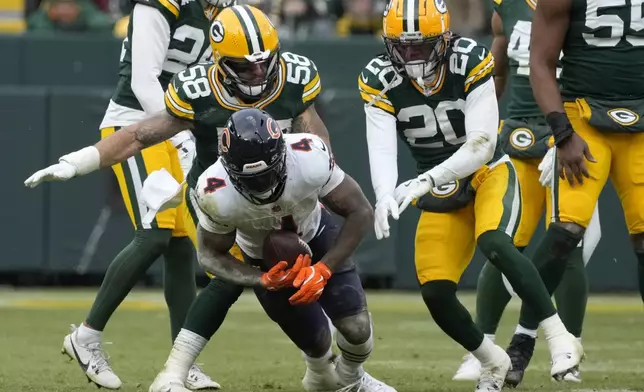 Chicago Bears running back D'Andre Swift (4) falls forward in front of Green Bay Packers linebacker Isaiah McDuffie (58) and safety Javon Bullard (20) during the second half of an NFL football game, Sunday, Jan. 5, 2025, in Green Bay, Wis. (AP Photo/Morry Gash)