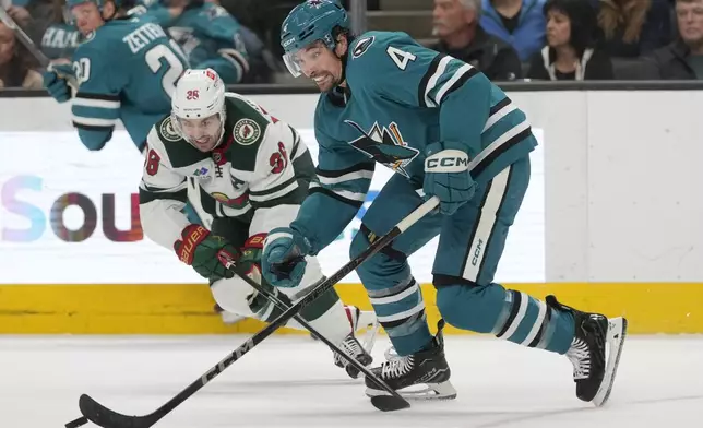 San Jose Sharks defenseman Cody Ceci (4) skates with the puck against Minnesota Wild right wing Mats Zuccarello (36) during the second period of an NHL hockey game in San Jose, Calif., Saturday, Jan. 11, 2025. (AP Photo/Jeff Chiu)