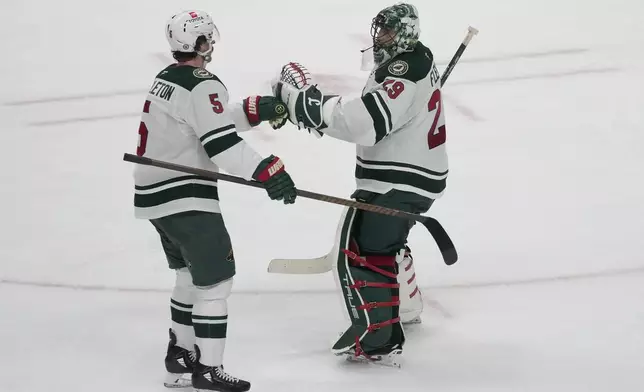 Minnesota Wild defenseman Jake Middleton (5) celebrates with goaltender Marc-Andre Fleury (29) after an NHL hockey game against the San Jose Sharks in San Jose, Calif., Saturday, Jan. 11, 2025. (AP Photo/Jeff Chiu)