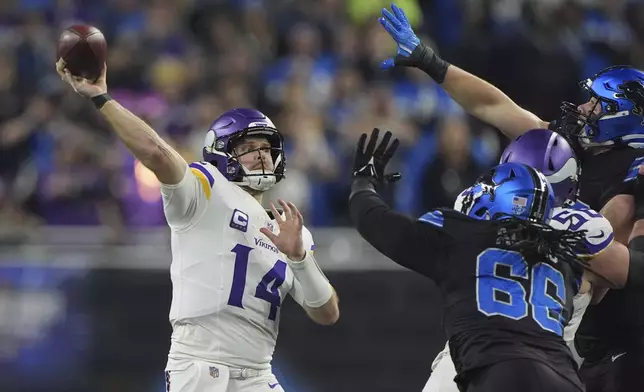 Minnesota Vikings quarterback Sam Darnold (14) throws against the Detroit Lions under pressure during the first half of an NFL football game Sunday, Jan. 5, 2025, in Detroit. (AP Photo/Charlie Riedel)