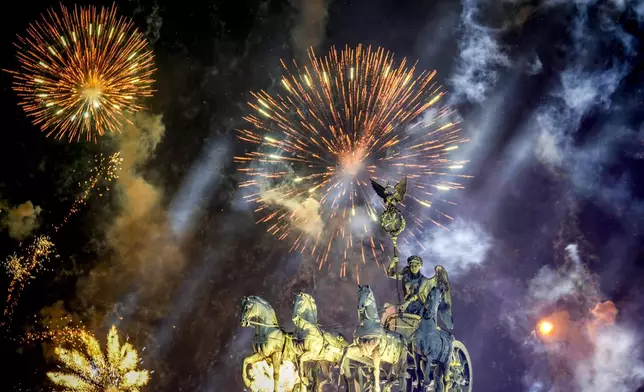 Fireworks light the sky above the Quadriga at the Brandenburg Gate during New Year's celebrations shortly after midnight in Berlin, Germany, Wednesday, Jan. 1, 2025. (AP Photo/Ebrahim Noroozi)