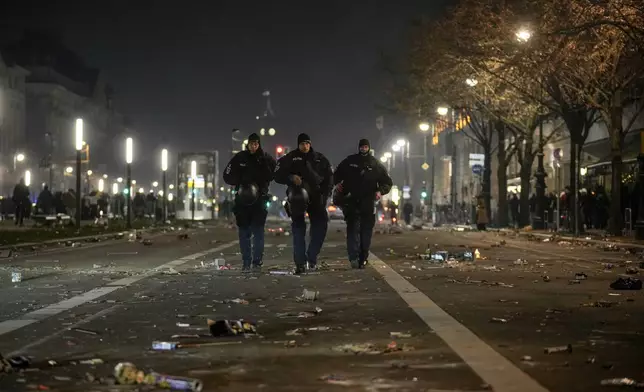 Police officers stand guard in the streets after fireworks for the New Year's celebrations in Berlin, Germany, Wednesday, Jan. 1, 2025. (AP Photo/Ebrahim Noroozi)