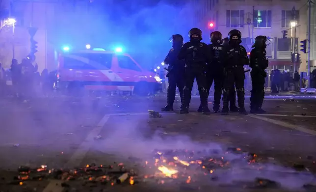 Police officers stand guard in the streets after fireworks for the New Year's celebrations in Berlin, Germany, Wednesday, Jan. 1, 2025. (AP Photo/Ebrahim Noroozi)