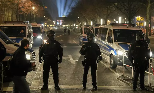 Police officers stand guard in the streets after the fireworks for the New Year's celebrations in Berlin, Germany, Wednesday, Jan. 1, 2025. (AP Photo/Ebrahim Noroozi)