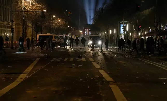 Police officers stand guard in the streets after fireworks for the New Year's celebrations in Berlin, Germany, Wednesday, Jan. 1, 2025. (AP Photo/Ebrahim Noroozi)