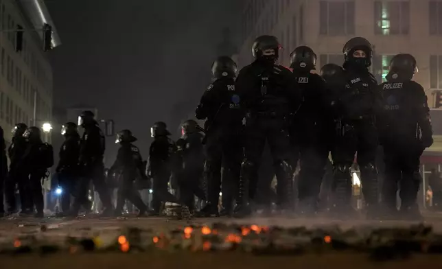 Police officers stand guard in the streets after fireworks for the New Year's celebrations in Berlin, Germany, Wednesday, Jan. 1, 2025. (AP Photo/Ebrahim Noroozi)