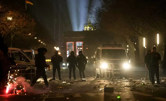 Police officers stand guard in the streets after fireworks for the New Year's celebrations in Berlin, Germany, Wednesday, Jan. 1, 2025. (AP Photo/Ebrahim Noroozi)