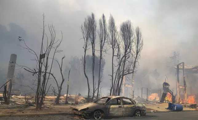 The Palisades Fire ravages a neighborhood amid high winds in the Pacific Palisades neighborhood of Los Angeles, Wednesday, Jan. 8, 2025. (AP Photo/Damian Dovarganes)