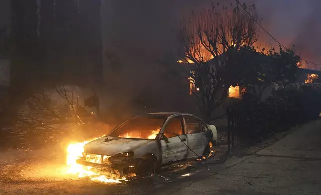 The Eaton Fire burns vehicles and structures Wednesday, Jan. 8, 2025 in Altadena, Calif. (AP Photo/Nic Coury)