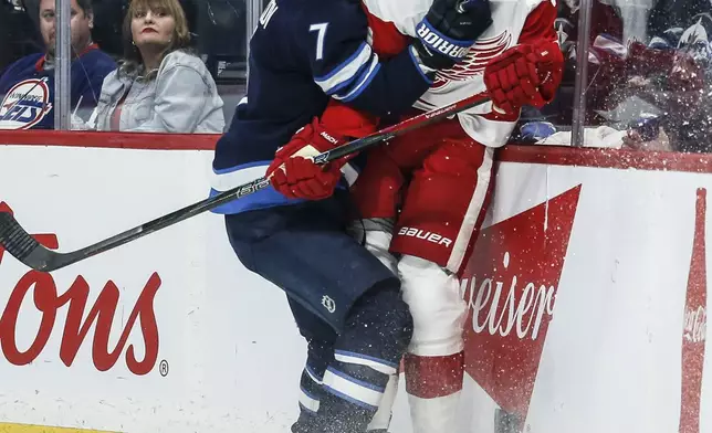 Winnipeg Jets' Vladislav Namestnikov (7) and Detroit Red Wings' Justin Holl (3) collide during second period NHL action in Winnipeg, Saturday, Jan. 4, 2025. (John Woods/The Canadian Press via AP)