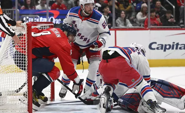 Washington Capitals left wing Alex Ovechkin, left, works his way out of the net after a pile up against the New York Rangers during the first period of an NHL hockey game Saturday, Jan. 4, 2025, in Washington. (AP Photo/John McDonnell)