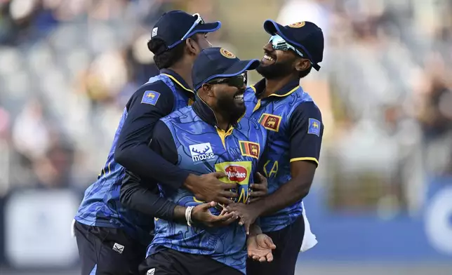 Sri Lanka's Wanindu Hasaranga takes a catch to dismiss New Zealand's Tom Latham and celebrates with teammates during the 3rd one day international cricket match at Eden Park in Auckland, New Zealand, Saturday, Jan. 11, 2025. (Andrew Cornaga/Photosport via AP)