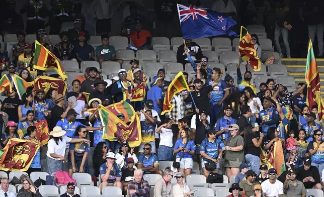 Fans and supporters cheer and wave flags during the 3rd one day international cricket match between New Zealand and Sri Lanka at Eden Park in Auckland, New Zealand, Saturday, Jan. 11, 2025. (Andrew Cornaga/Photosport via AP)