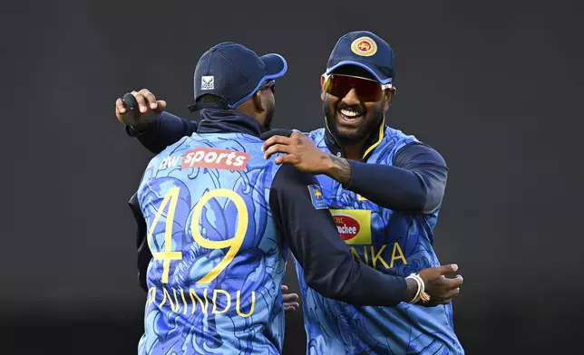 Sri Lanka's Wanindu Hasaranga takes a catch to dismiss New Zealand's Tom Latham and celebrates with teammate Avishka Fernando during the 3rd one day international cricket match at Eden Park in Auckland, New Zealand, Saturday, Jan. 11, 2025. (Andrew Cornaga/Photosport via AP)