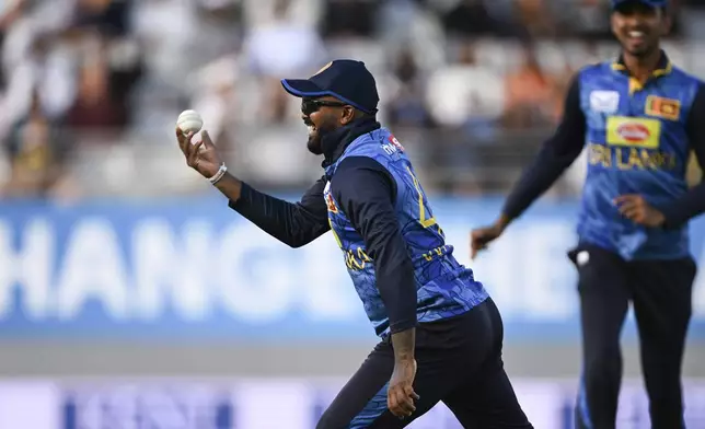 Sri Lanka's Wanindu Hasaranga takes a catch to dismiss New Zealand's Tom Latham during the 3rd one day international cricket match at Eden Park in Auckland, New Zealand, Saturday, Jan. 11, 2025. (Andrew Cornaga/Photosport via AP)
